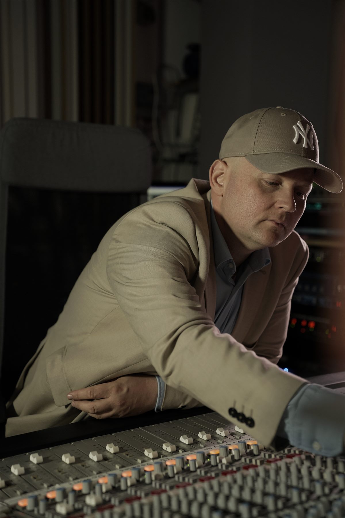 Engineer leaning over the mixing console during a session